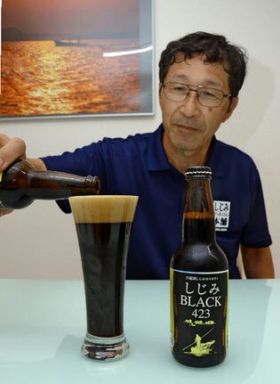 シジミのビールを注ぐ原秀範社長＝出雲市斐川町荘原