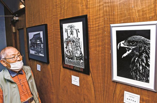 細微まで切り抜いた作品に見入る来場者＝益田市あけぼの東町、ちいさなぎゃらりーうつわ