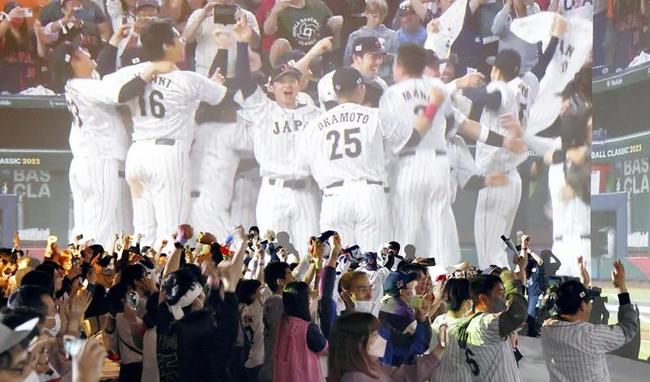 ＷＢＣ優勝を決めた日本代表選手たちの映像とともに喜ぶ、パブリックビューイング会場の人たち＝２２日午前、東京都港区