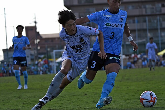 後半、相手と競り合いながら駆け上がるＦＣ神楽しまねの澤島輝（左）