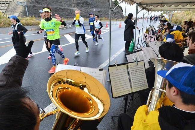 中学生たちの演奏に顔をほころばせるランナー＝松江市美保関町下宇部尾