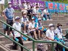 試合を見つめる保護者たち。スタンドには江津、浜田水産両校の横断幕が並んでいた＝１３日、松江市営野球場