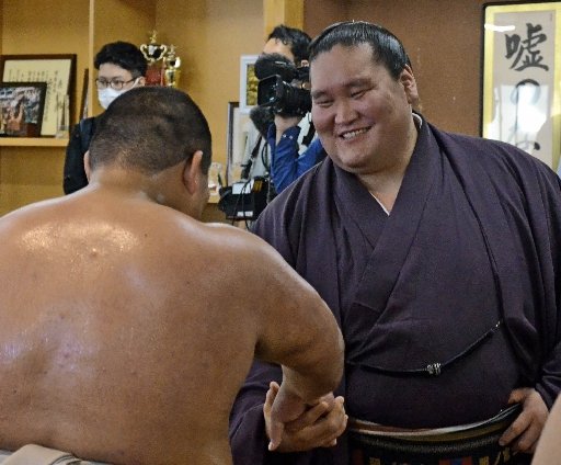 鳥取城北高校相撲部の部員と握手する照ノ富士関（右）＝鳥取市西品治、鳥取城北高校