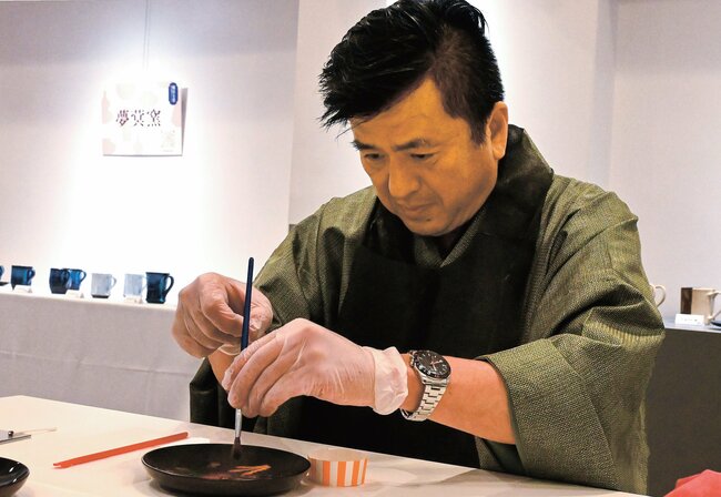 真剣な表情で漆をのせる参加者＝松江市殿町、カラコロ工房