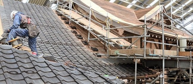 ＪＲ旧大社駅で瓦のふき替え作業を進める作業員＝出雲市大社町北荒木