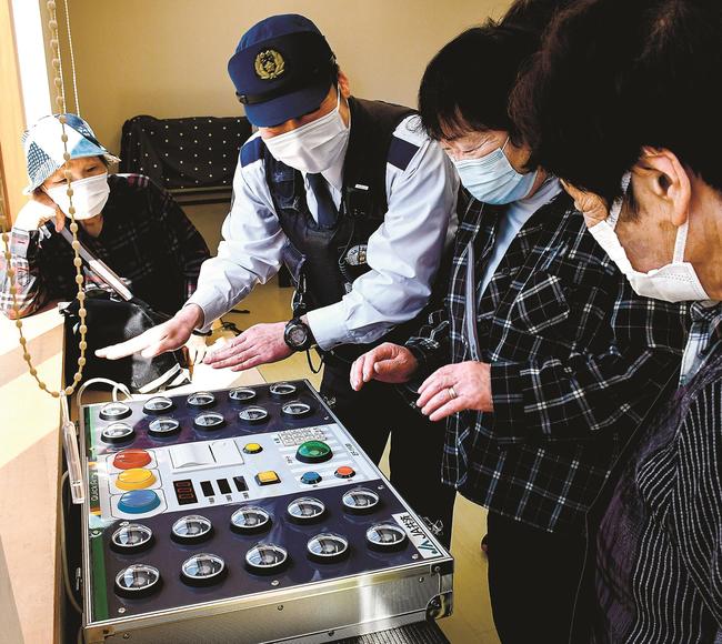 交通安全講習で反応速度の測定を体験する住民＝島根県邑南町下田所、田所公民館