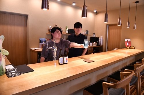 カフェバー「MAHORA」をオープンした河野弘さん(右)と妻の涼さん=大田市温泉津町温泉津、なかのや旅館