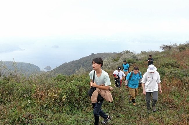 雄大な日本海を背に古道を登る参加者＝島根県知夫村