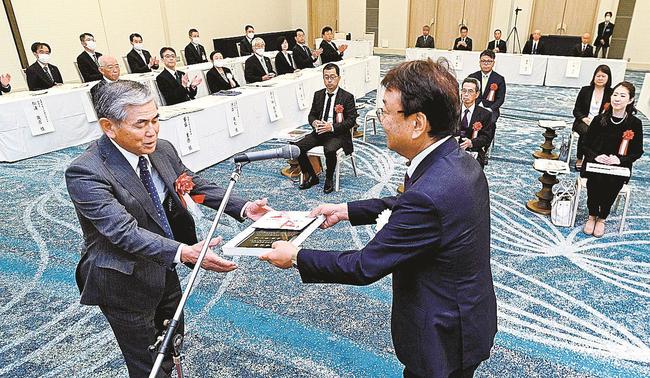 松尾倫男社長（右）から表彰賞状を受け取る砂流啓二さん＝松江市千鳥町、ホテル一畑