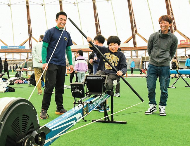 練習用のマシーンを使って、カヌーの体験をする子ども＝出雲市矢野町、出雲ドーム