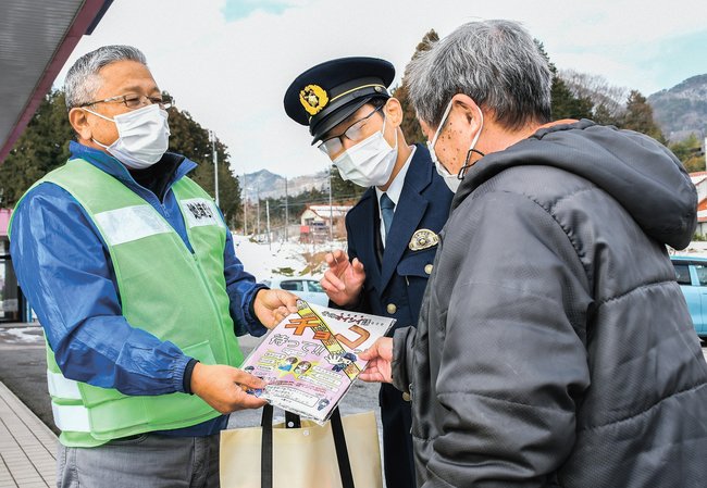住民(右)にチラシを配る参加者=島根県邑南町矢上、あいタウンアベル
