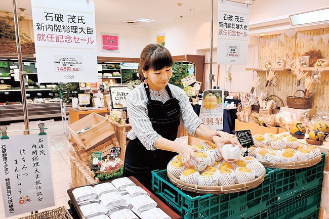 石破茂氏の好物などを１４８円の価格で店頭に並べるスタッフ＝鳥取市今町２丁目、丸由百貨店