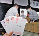
          
１０月の値上げで１枚８５円となった年賀はがきの見本と仕分けする郵便局員＝松江市東朝日町、松江中央郵便局
        