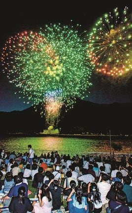 境水道で打ち上げられる花火に見入る来場者＝境港市浜ノ町