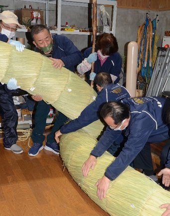 ２本の太い縄をより合わせる組合員たち＝島根県飯南町花栗、町大しめなわ創作館
