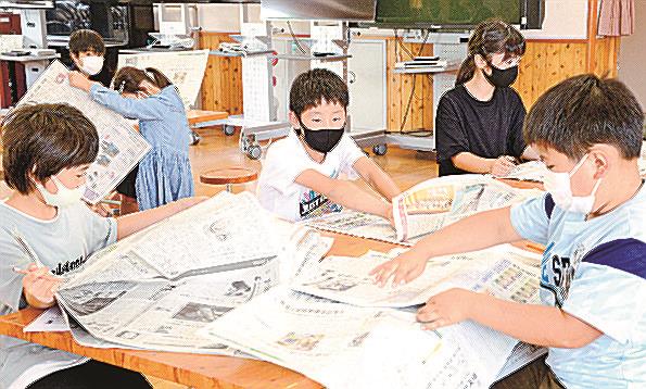 当日の本紙から答えを探すゲームをする児童＝出雲市稲岡町、北陽小