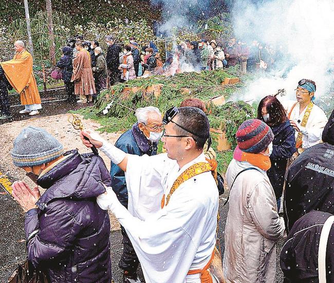 燃える護摩壇のそばで御加持を受ける参拝者＝安来市清水町、清水寺