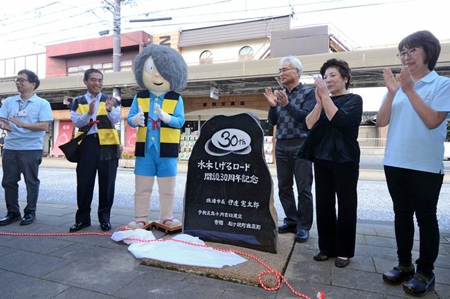 設置を祝う松ケ枝町商店街の関係者ら=境港市松ケ枝町、水木しげるロード