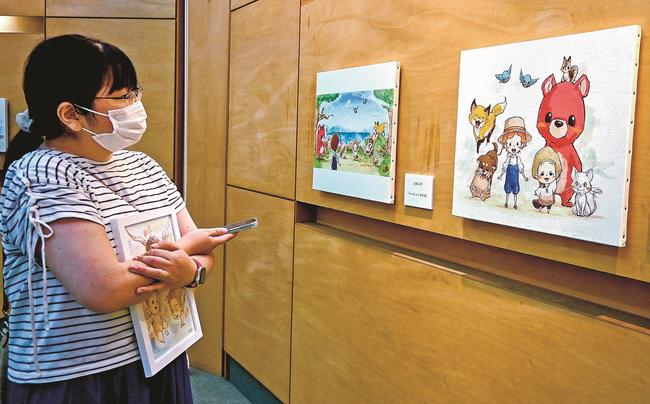 Ｐｏｒｉさんのイラストを鑑賞する来場者＝松江市宍道町宍道、ギャラリーＣ