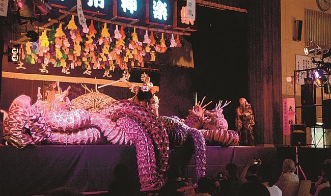 ステージ狭しと「大蛇」を演じる石見神楽佐野神楽社中＝浜田市佐野町、石見まちづくりセンター佐野分館