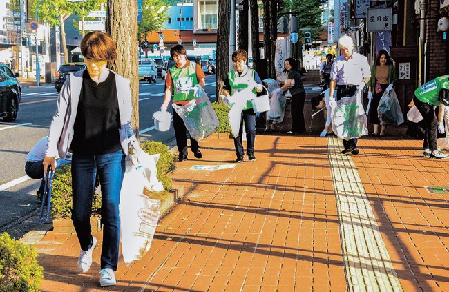 きれいな繁華街を訪れてもらおうと、ごみを拾い歩く参加者＝米子市明治町