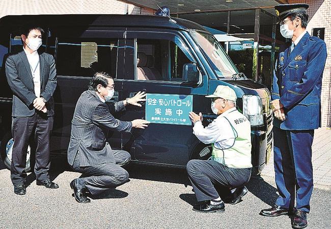 青色回転灯が付けられた公用車を披露する清原正義学長（左から２人目）や佐々木肇署長（右）ら＝浜田市野原町、島根県立大浜田キャンパス