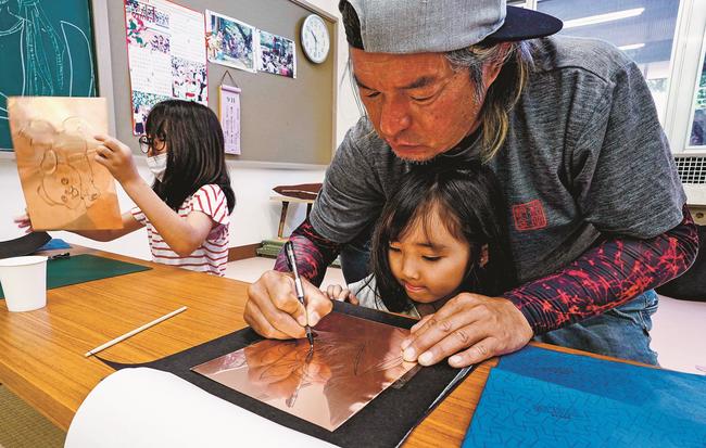 和田瑞希代表（右奥）に教わりながら、作業を体験する子どもたち＝島根県美郷町簗瀬、吾郷公民館