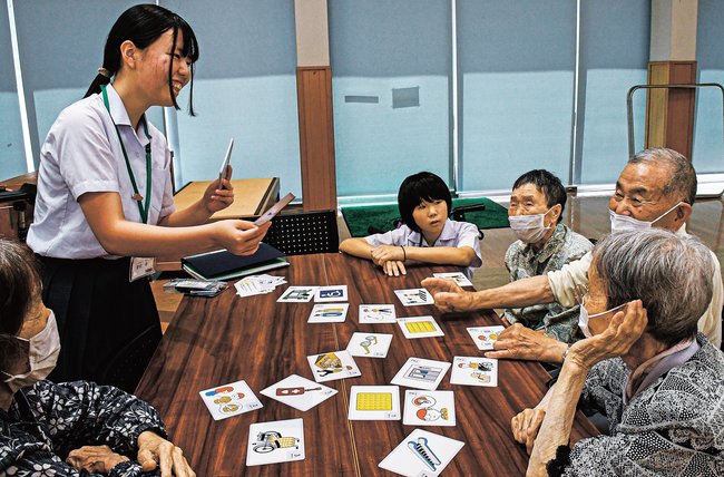 かるた形式のクイズで交流する高齢者と吉田中学校の生徒＝雲南市吉田町深野、ケアポートよしだ
