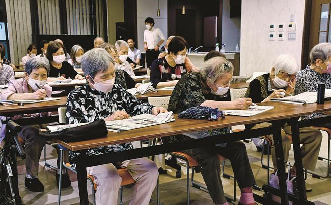 新聞記事をじっくりと読む参加者＝松江市寺町、松江センターアゼリア