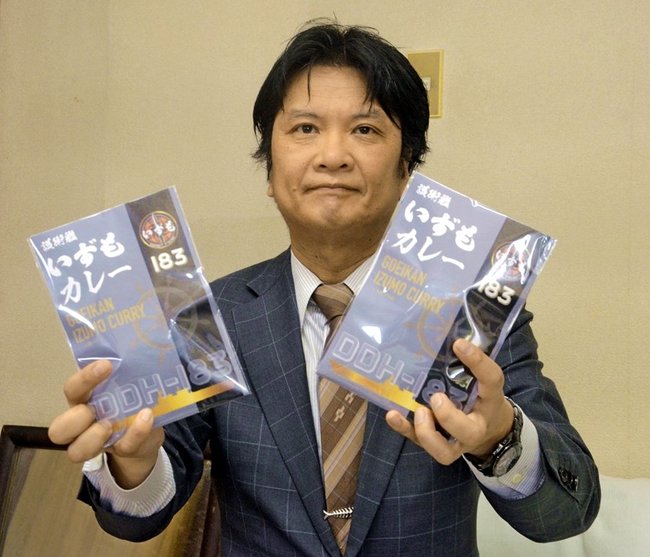 「護衛艦いずもカレー」を手にする西尾貴延社長＝出雲市灘分町、マルニシ物産