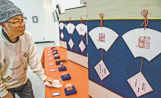 甲子会の篆刻作品に見入る来場者＝松江市殿町、島根県民会館