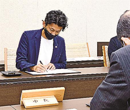 協定書に署名する沖野賢治代表理事〓（?）浜田市殿町、市役所