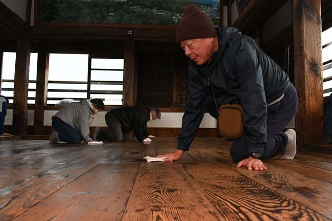 松江城天守の床を磨く参加者＝松江市殿町、松江城