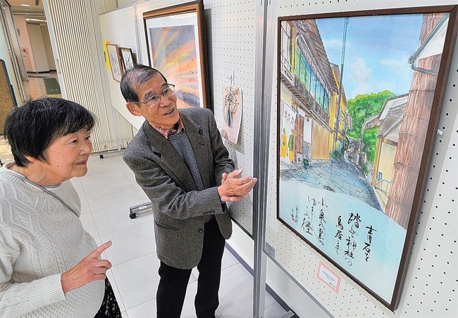 ばけばけをテーマにした合作を紹介する水野博司さん(右)と清槙さん=松江市白潟本町、市民活動センター