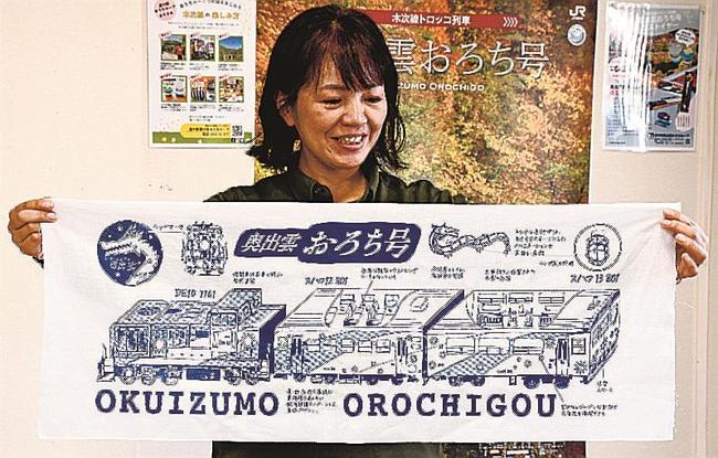 販売が始まったトロッコ列車・奥出雲おろち号の手拭い＝雲南市木次町里方、市観光案内所