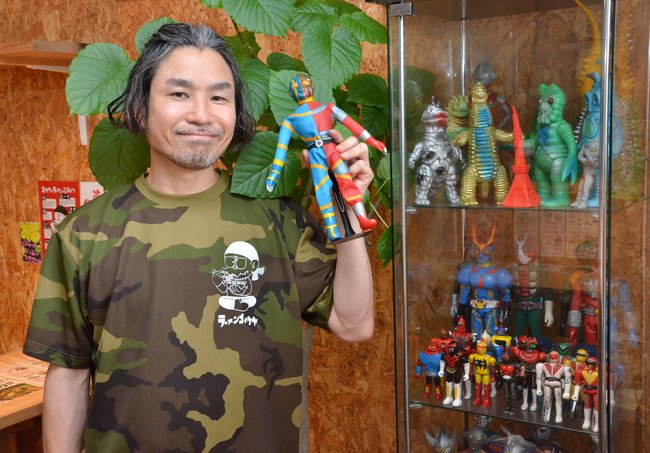 店舗の一角にある昭和コーナー前でほほ笑む周藤啓悟さん