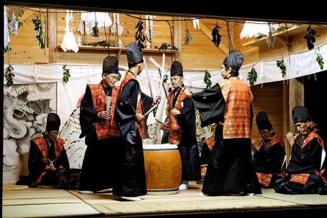 勇壮に剣舞を披露する会員たち＝島根県隠岐の島町久見、伊勢命神社神楽殿