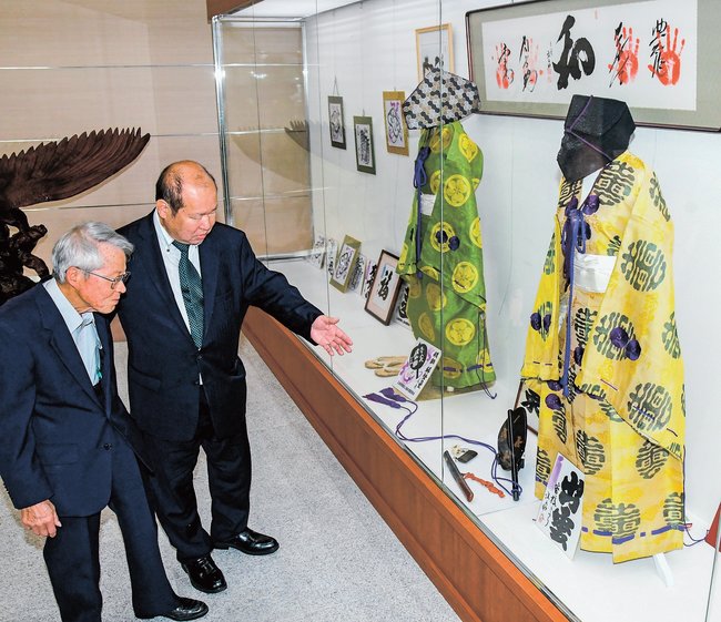 今岡英樹さん（右）と展示品を見る角森茂さん＝出雲市今市町、ＪＡしまね出雲地区本部
