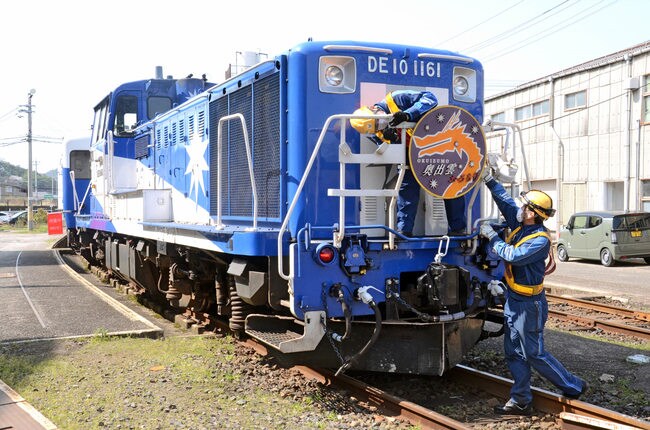ヘッドマークを取り付ける作業員＝米子市目久美町、ＪＲ後藤総合車両所運用検修センター