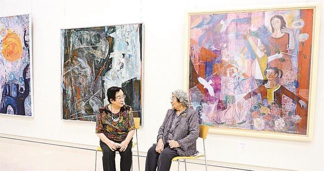 ６回目の姉妹展で、大作を背に言葉を交わす田辺二枝さん（左）と山﨑一枝さん＝松江市袖師町、島根県立美術館