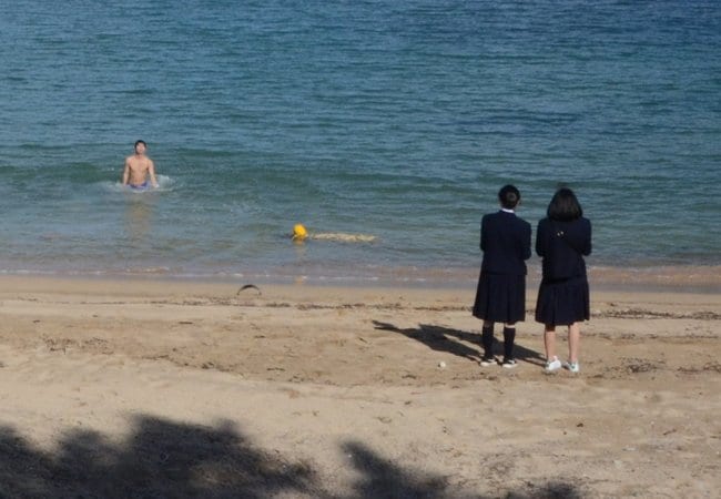寒いのに海水浴をする生徒たち