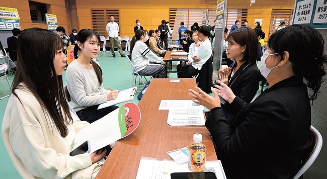 企業の担当者（右側）から話を聞く大学生＝浜田市野原町、島根県立大浜田キャンパス