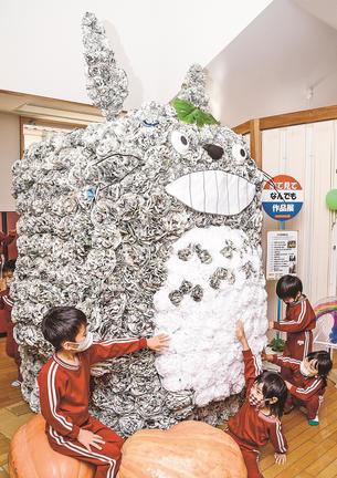 新聞紙で作られた身長の倍近くあるトトロを触って楽しむ子どもたち＝浜田市金城町下来原、さんあいホーム
