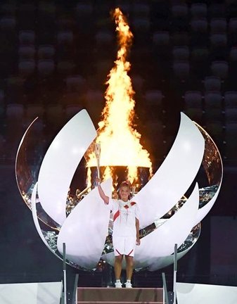 東京五輪の開会式で聖火台に点火し、トーチを掲げるテニス女子の大坂なおみ＝２３日夜、国立競技場