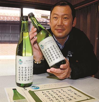 「特別純米三隅氏発祥８００年記念ボトル」を手にする藤田真路社長＝浜田市三隅町湊浦、日本海酒造