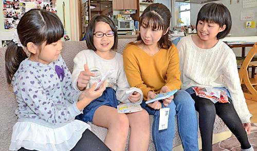 フェアトレード商品を手に話し合う（右から）長女の鳥居こころさん、母いづみさん、次女ももかさん、三女きららさん＝島根県邑南町井原
