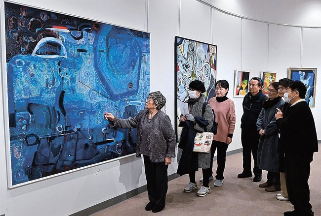 作品「わたしはわたし」を来場者に説明する山﨑一枝さん（左端）＝安来市安来町、和鋼博物館市民ギャラリー