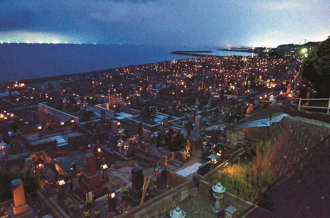 いさり火を望む花見潟墓地でともされた「迎え火」＝鳥取県琴浦町赤碕