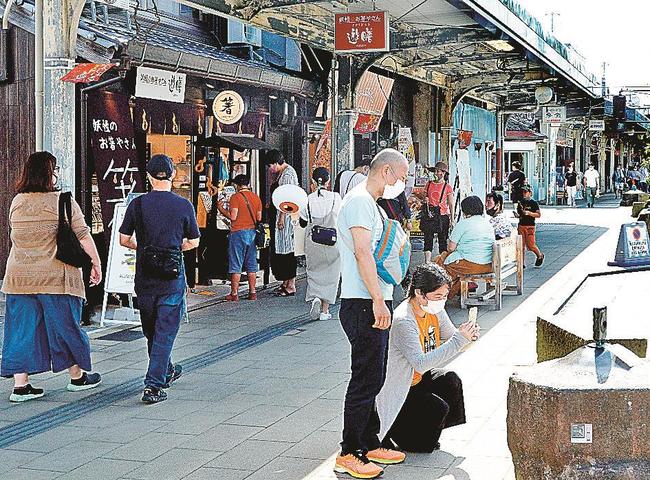 妖怪ブロンズ像が並ぶ水木しげるロードを散策する観光客=22日午後3時、境港市松ケ枝町