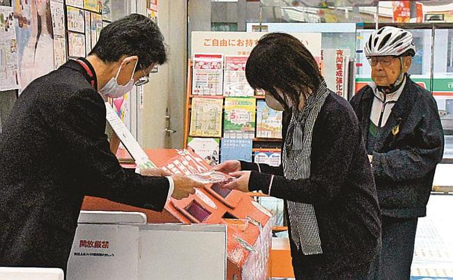 年賀状を投函し、オリジナルグッズを受け取る来店者=松江市東朝日、松江中央郵便局